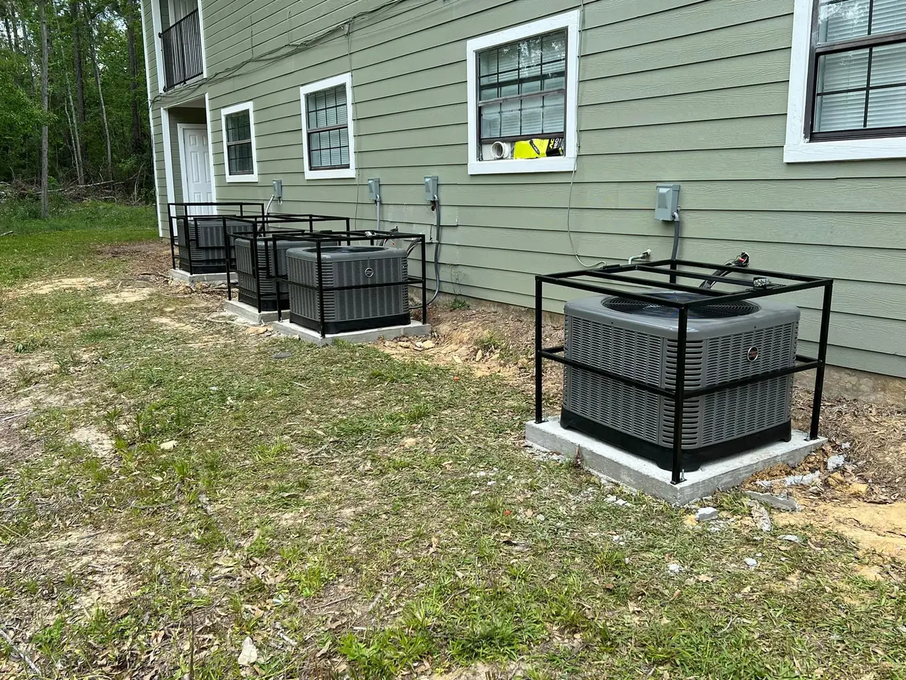 Caged condensing units installed beside an apartment building