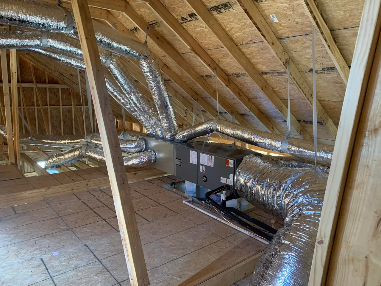 New air handler and insulated ductwork in a home attic