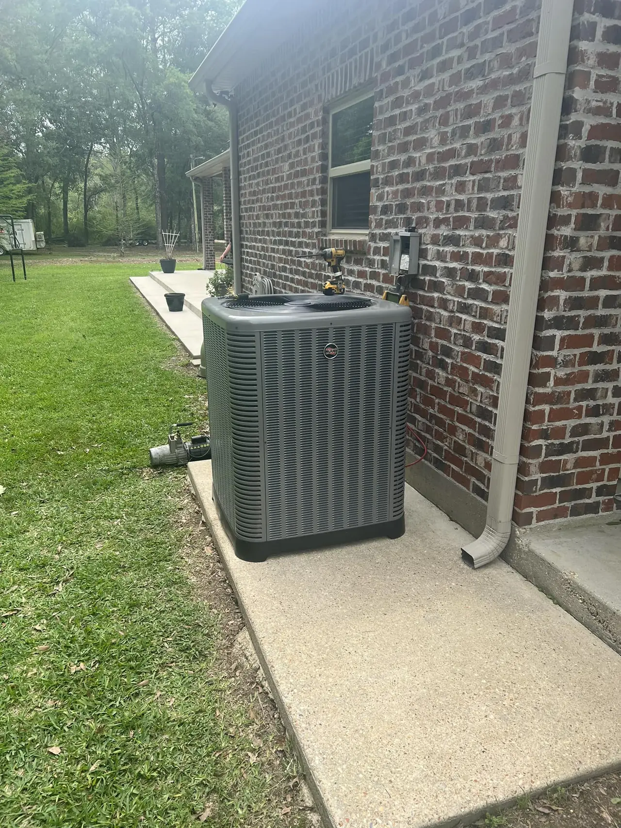 AC condenser installed beside a brick home