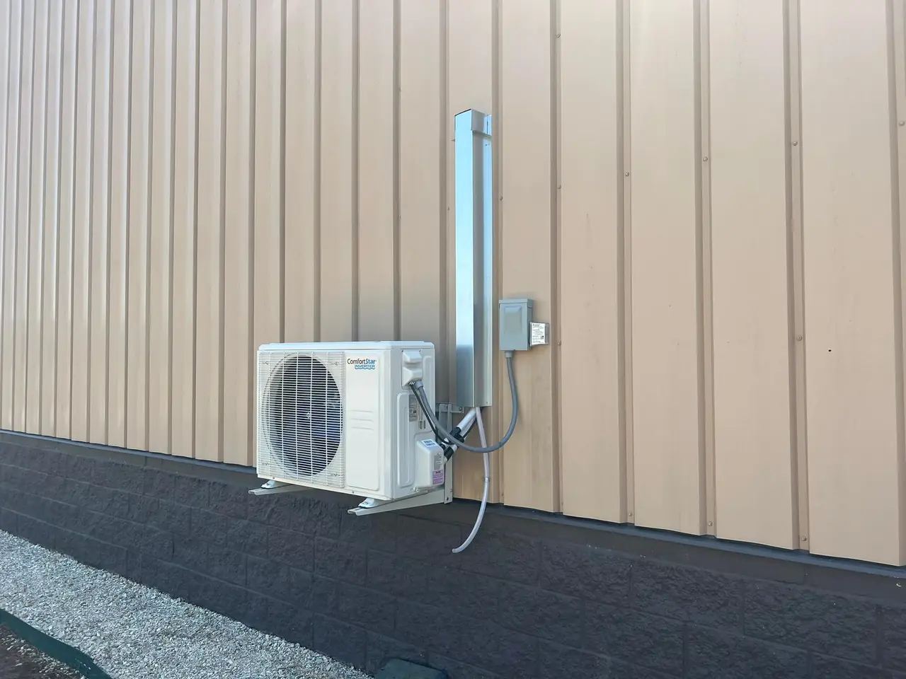 Ductless mini-split condenser mounted on a metal commercial building