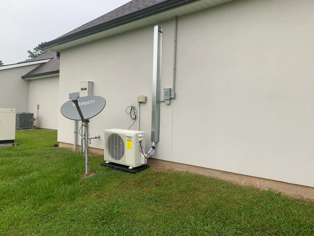 Ductless mini-split condenser installed beside a home