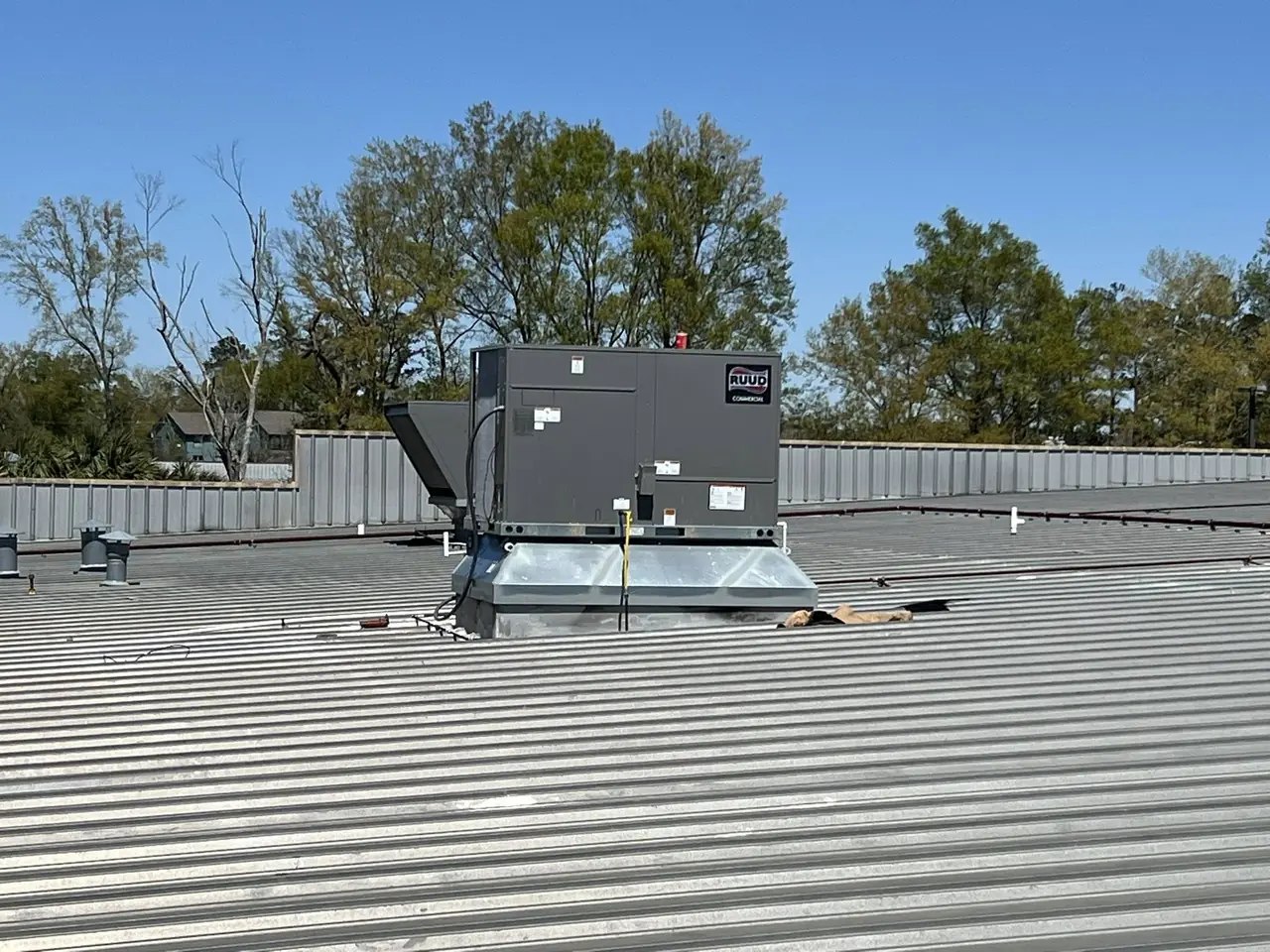 New rooftop unit and curb on a metal commercial roof