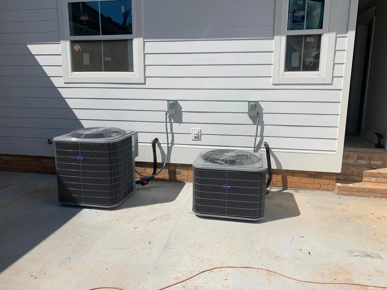 Two new AC condensers on a slab at a new home